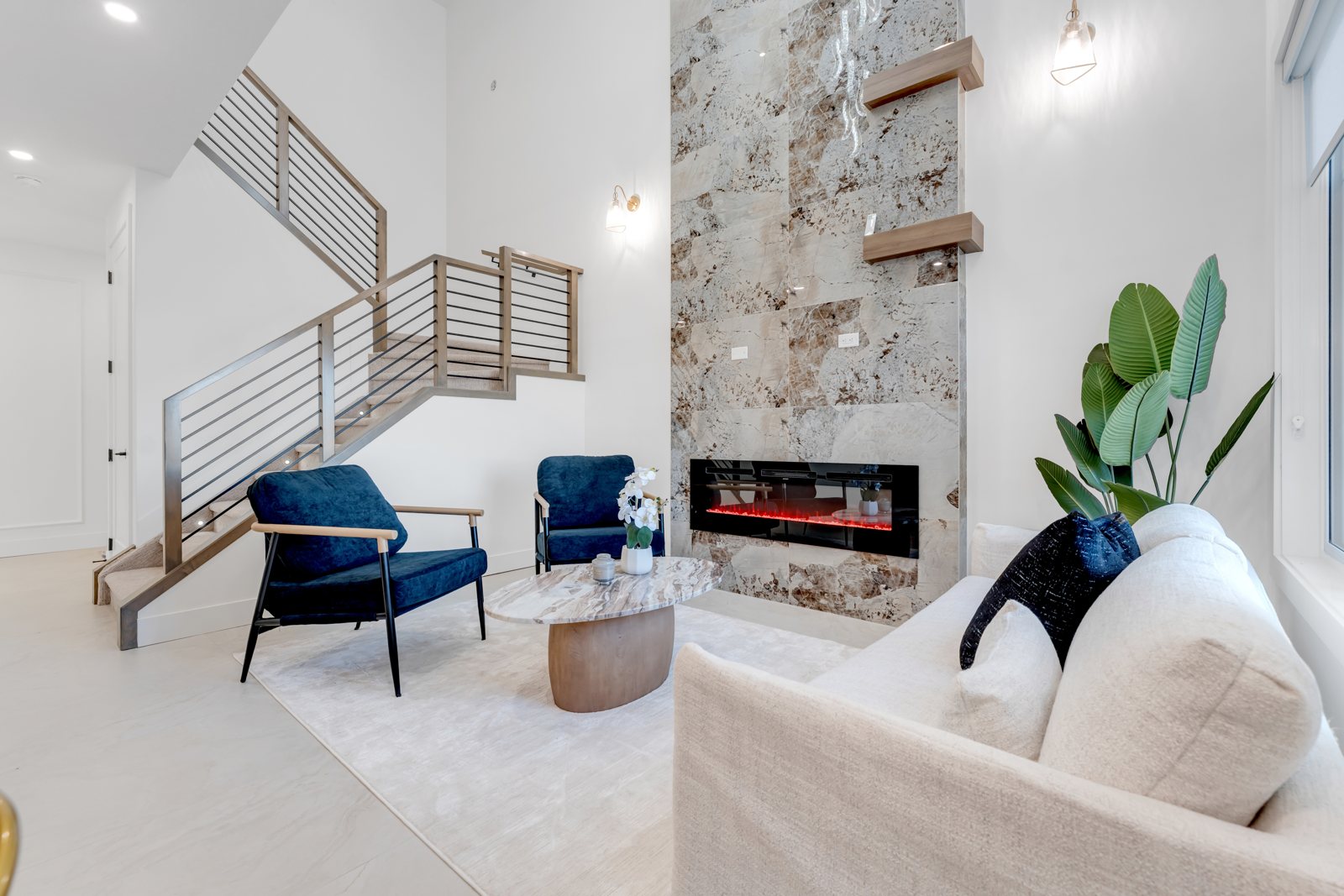 G Homes Corp open-concept living room with a stone feature fireplace and open-riser staircase